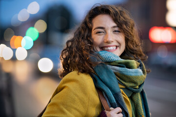 Smiling woman on city street during evening