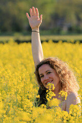 Naklejka na ściany i meble woman with yellow flowers field landscape background