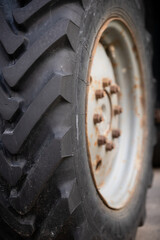 Selective focus on the tread of a huge wheel of a Belarus tractor. Strong tire tread on the wheel. Rural life