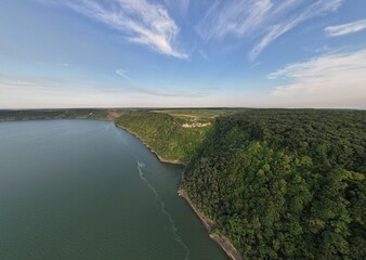 Aerial panoramic view of huge river, green pine forest near the river. Summer morning. Panoramic landscape.