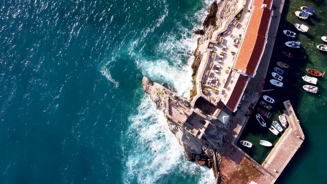 quadcopter spirals to the right over the citadel of Montenegro, Petrovac. The waves crash against the rock on which the fortress stands