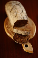 Sliced black bread on the wooden board and dark table