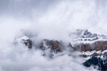 Close view of mountain landscape in snowy winter with fog and low clouds, Pyrenees, national park, Spain.