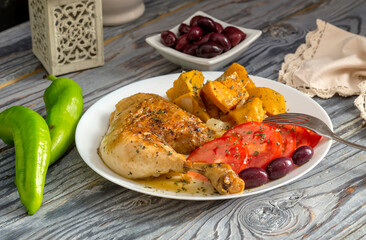 Stewed chicken leg and sweet potatoes (Ipomoea batatas) lie on a white plate close-up