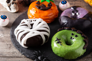 Assortmen of Halloween donuts on wooden table