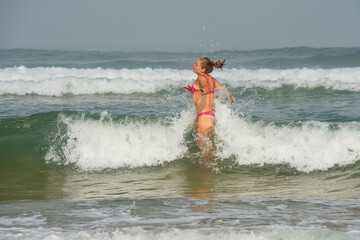 beautiful young woman having fun in the waves