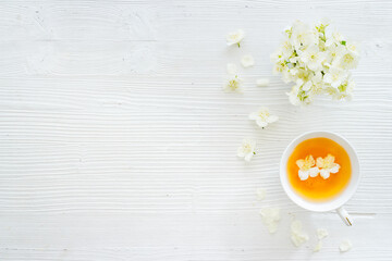 Obraz na płótnie Canvas Cup of jasmine herbal tea with white flowers. Top view