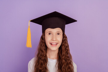 Portrait of dreamy funny girl look up empty blank space excited face wear bachelor hat on purple background