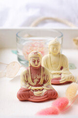 Candles of Buddha statue on a white background. Meditation, spa, relaxation concept.