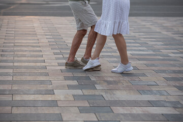 Couple dancing on street. legs of dancing people