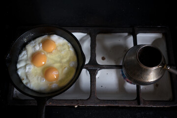 Making scrambled eggs and a coffe on the gas oven