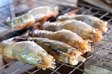 Grilled Giant River Prawns On Fire. Photo of cook by grilling shrimp with Charcoal  in Traditional Thai style.