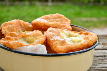 Traditional Bulgarian home made deep fried  patties  covered with sugar  оn rustic backgroud.Mekitsa or Mekica,  on wooden  rustic  background. Made of kneaded dough that is deep fried 