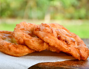 Traditional Bulgarian home made deep fried  patties  covered with sugar  оn rustic backgroud.Mekitsa or Mekica,  on wooden  rustic  background. Made of kneaded dough that is deep fried 