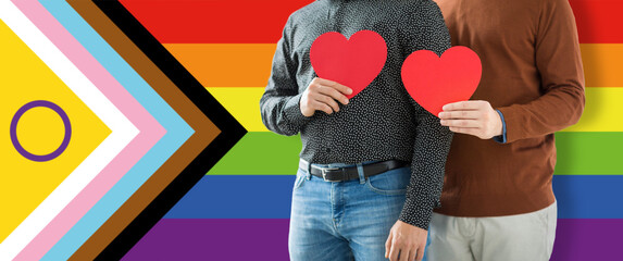 lgbtq, trans and intersex rights concept - close up of male gay couple with red hearts over...