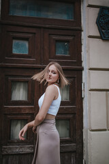 Fototapeta premium a beautiful young girl is walking around the city, spinning, dancing on the street