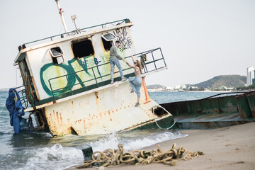 Young love couple have fun on vacation. Grunge style. old boat on the seaside. Ocean view. High quality photo