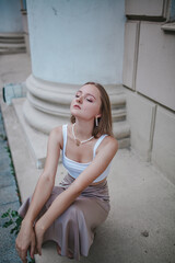 a beautiful girl in a skirt and top walks near the theater