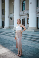 a beautiful girl in a skirt and top walks near the theater