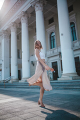 a beautiful young girl is walking around the city, spinning, dancing on the street