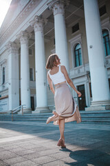 a beautiful young girl is walking around the city, spinning, dancing on the street