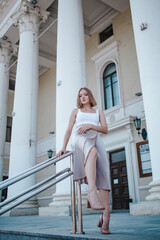 a beautiful girl in a skirt and top walks near the theater