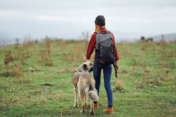 woman with backpack on her back nature tourism walking dog