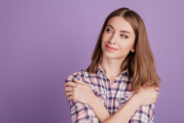 Fototapeta premium Portrait of nice-looking sweet lovable girl hugging herself look empty space isolated over violet background