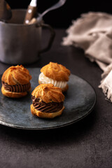 chocolate and cream profiteroles on black background