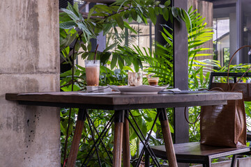 Fototapeta na wymiar Bakery and iced coffee on wooden table with green garden background. Food and Drink, Copy space, Selective focus.