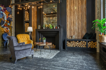 dark brutal interior of sitting room decorated with wooden logs. yellow and grey soft armchairs,...