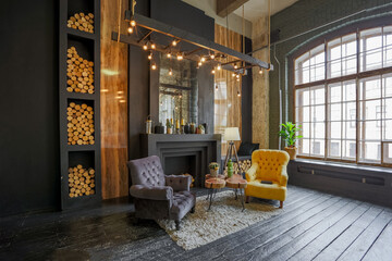 dark brutal interior of sitting room decorated with wooden logs. yellow and grey soft armchairs,...