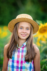 Portrait of a cute little girl in a field of sunflowers