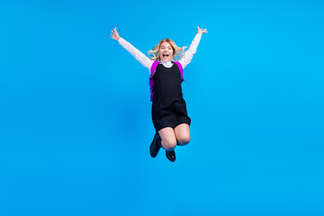 Fototapeta na wymiar Full size photo of crazy happy active girl jump up winner wear backpack smile isolated on blue color background