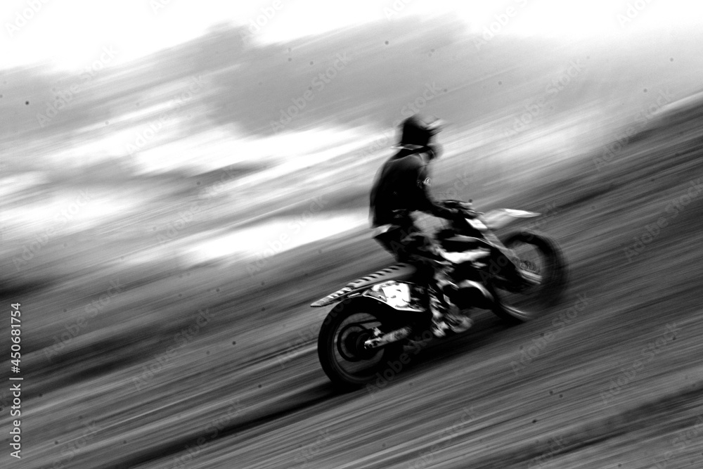 Wall mural grayscale shot of a driver on his motorcycle, driving really fas