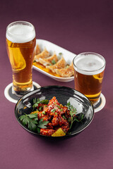 Japanese gedza and karaage chicken with beer on purple background