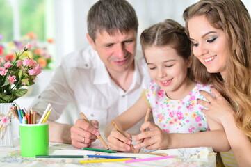 girl with mother and father  drawing at  home