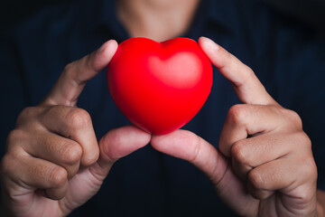 Hands of holding red heart shape. Close-up photo. Sign of love, healthcare, valentine's day, world heart day concept