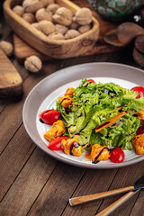 Salad with lettuce and fried chicken on wooden background