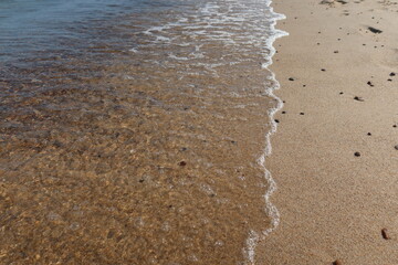 Soft sea wave on clean sandy beach. Abstract sand of beach and soft wave background. Top view
