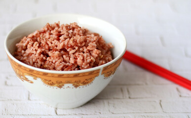 Steamed red rice on white bowl. 