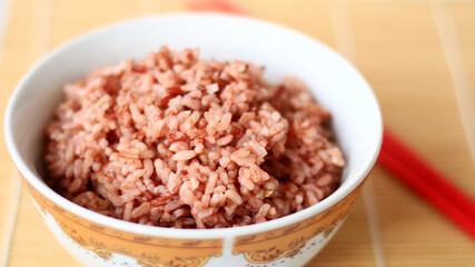 Steamed red rice on white bowl. 
