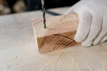 Close-up of carpenter using electric drill in workshop and routing out holes Cabinetmaker drilling...