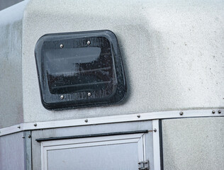 Window of a horse trailer under the rain