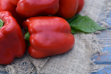 Red sweet peppers fresh vegetables closeup paprika on yute cloth on old woods..