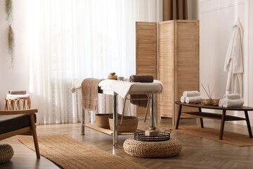 Stylish room interior with massage table in spa salon