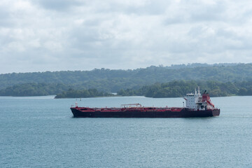 Landscape of Panama Canal, with cargo ship sailing through Gatun Lake on her way to the Pacific Ocean. 