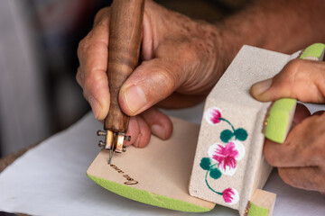 Hand of an artisan engraving a souvenir, Holguin, Cuba