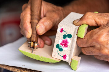 Hand of an artisan engraving a souvenir, Holguin, Cuba