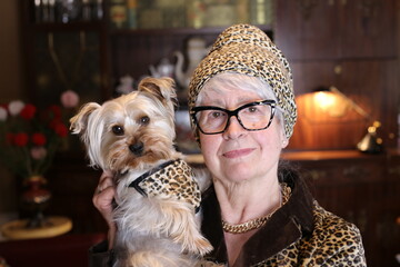 Glamorous lady wearing leopard print outfit and holding little dog
